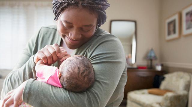 A woman cradles her baby in her arms
